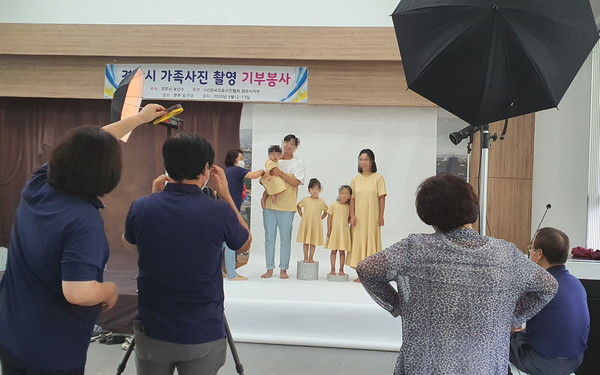 한국프로사진협회 경주지부 회원들이 '다둥이 가정'에게 사진기부재능을 하고 있다 / 경주시보건소